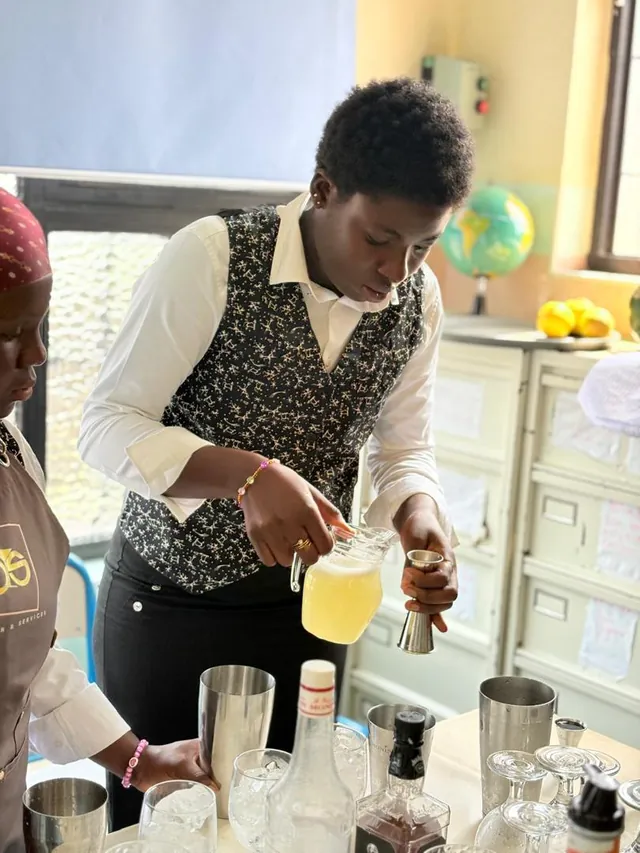 Une étudiante dose un jus au jigger