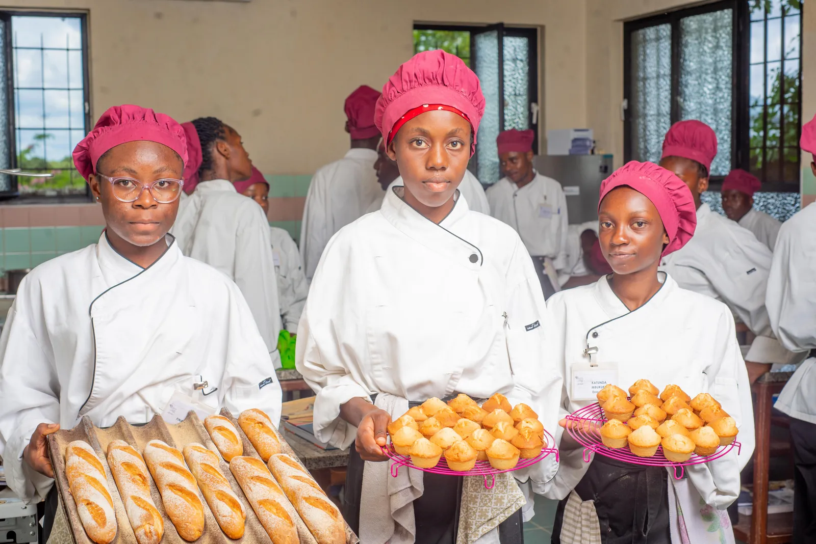Trois étudiantes présentent leurs baguettes et leurs madeleines