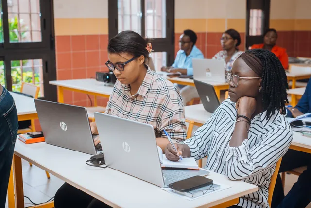Deux enseignantes en session de formation : l’une sur ordinateur, l’autre prend des notes