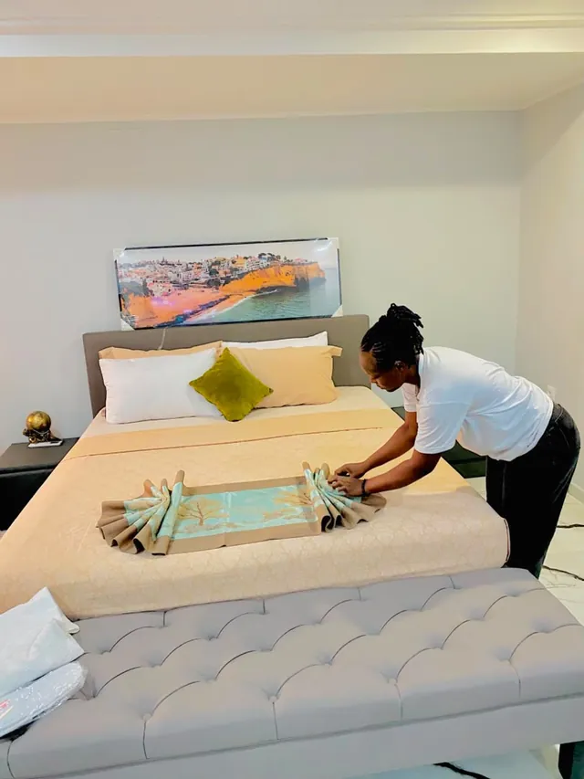 Une étudiante dispose le chemin de lit dans une chambre d’hôtel