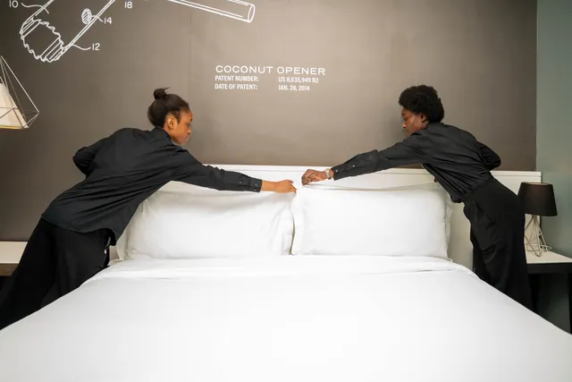 Deux étudiantes tirent la couette ensemble, de part et d’autre du lit.