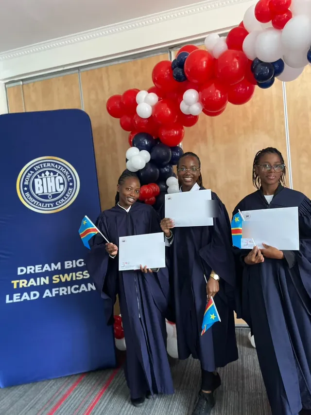 Trois étudiantes certifiées devant le totem du Boma International Hospitality College