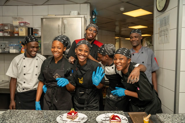 La brigade de pâtisserie pose derrière les entremets qu’elle vient de terminer.