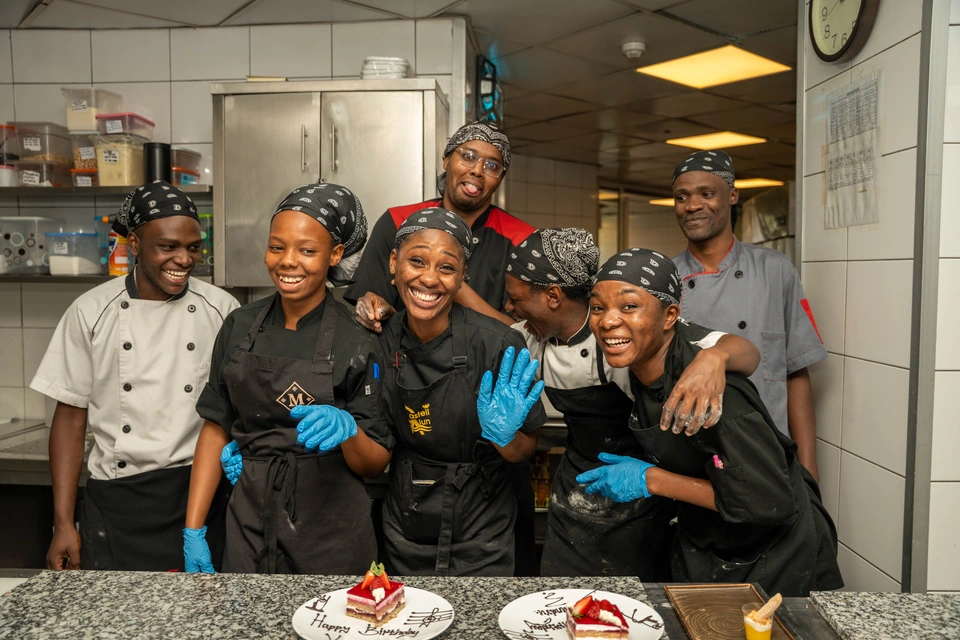 La brigade de pâtisserie pose derrière les entremets qu’elle vient de terminer.