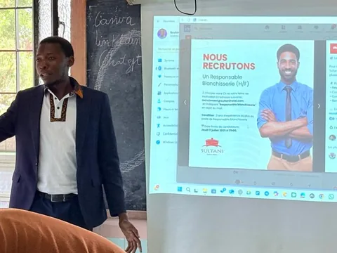 Un intervenant présente une offre d’emploi projetée au tableau.